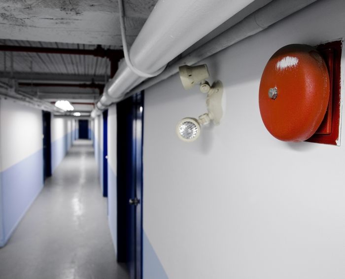 Fire Bell Alarm (red) with emergency light too in a long blue corridor.