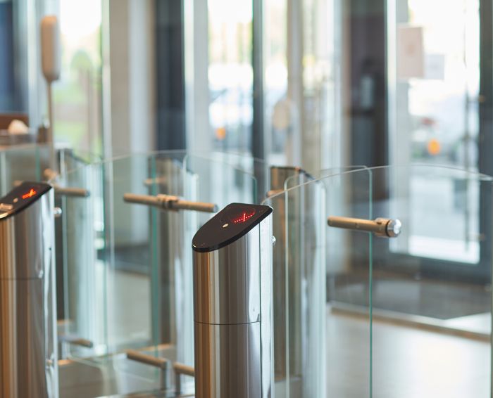 Background of glass doors with automated gate at entrance to office building or college, copy space